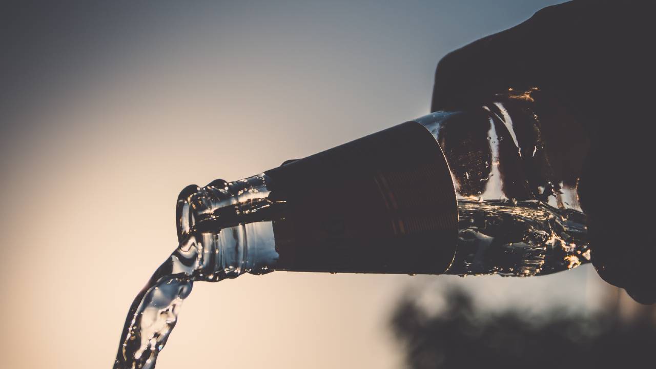 Water pouring out of a bottle at a steady flow with no bottleneck.